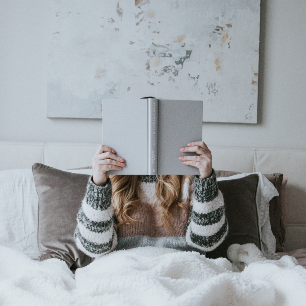 Cancer - under your covers - woman sitting on bed reading a book