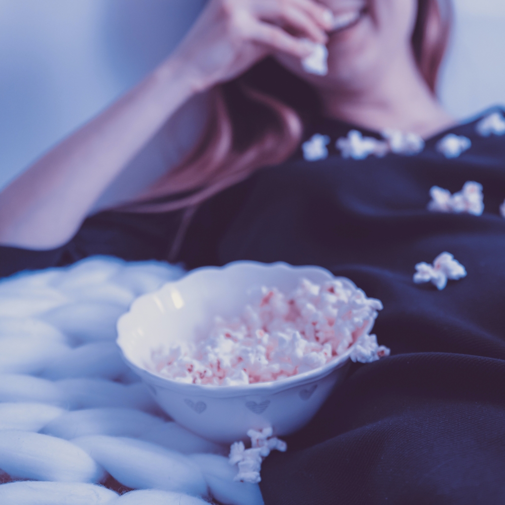 Taurus - netflix tagger tester - woman lying in bed eating popcorn