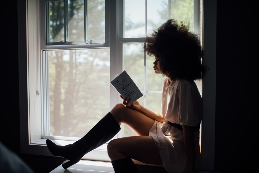 Gemini - Historical Fiction - model sitting on window seat while reading a book