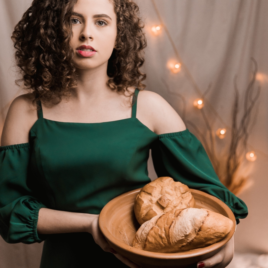 Host a baking party - model standing and holding a bowl of freshly baked bread