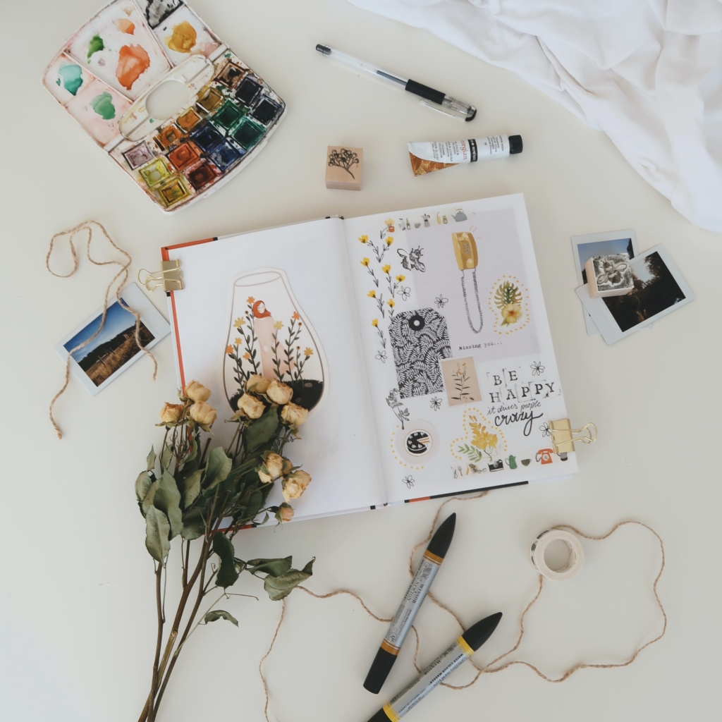 Start a scrapbook - scrapbook on white sheet with scrapbooking supplies and yellow roses around it